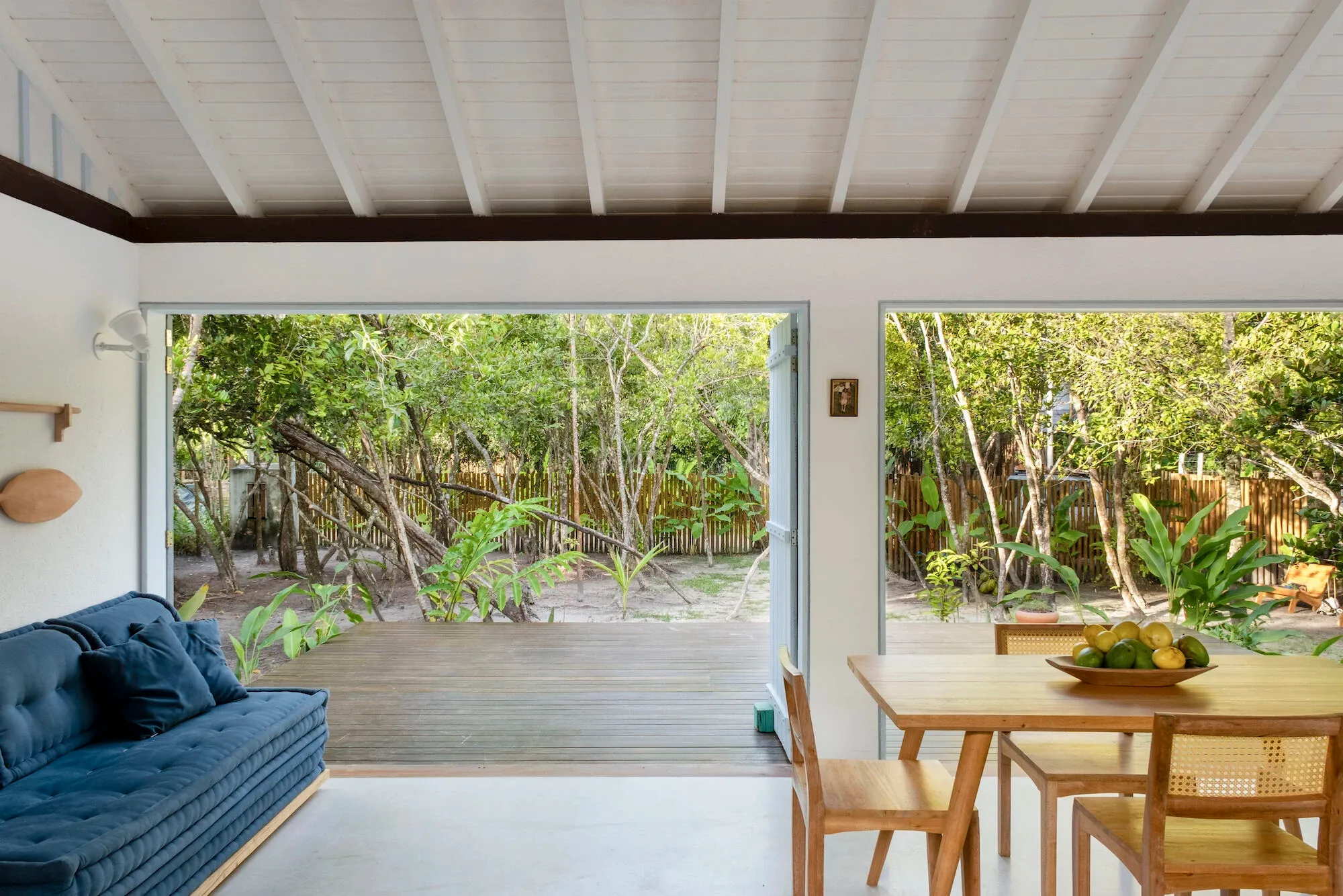 Sala e cozinha integradas, com as portas abertas para o deck