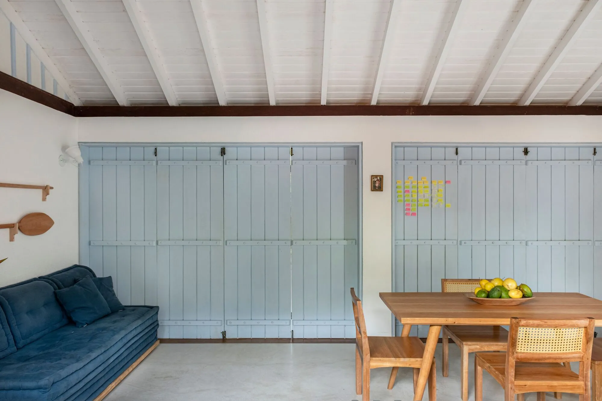 Sala com as portas azuis fechadas, sofá e mesa