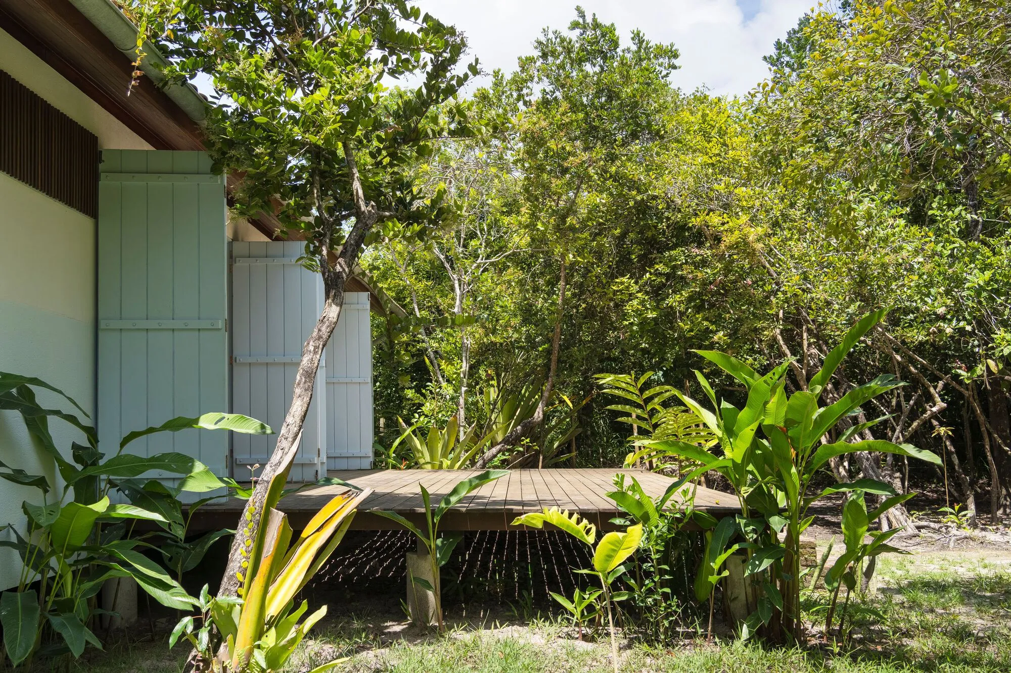 Lateral externa da casa, com vegetação e deck