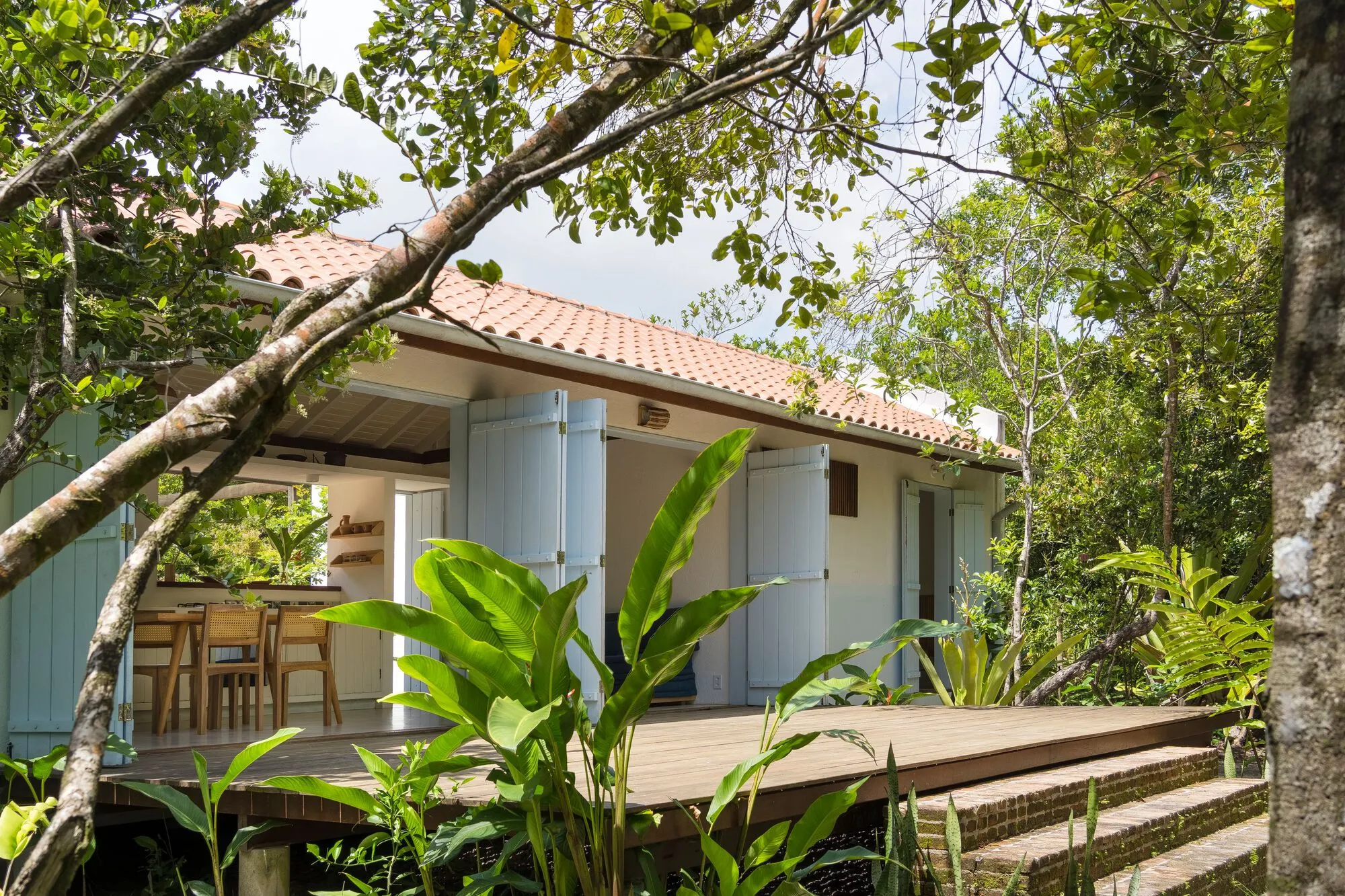 A casa entre as árvores, com a mesa posta no deck